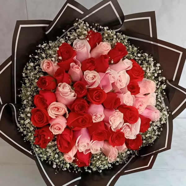 Bouquet of red and pink roses wrapped in dark paper