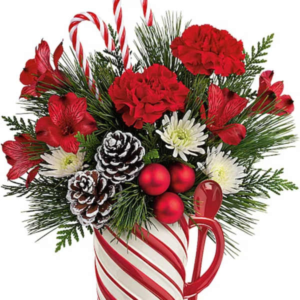 Holiday bouquet in a candy cane mug with red flowers and pinecones