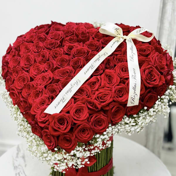 Heart-shaped bouquet of red roses with a white ribbon