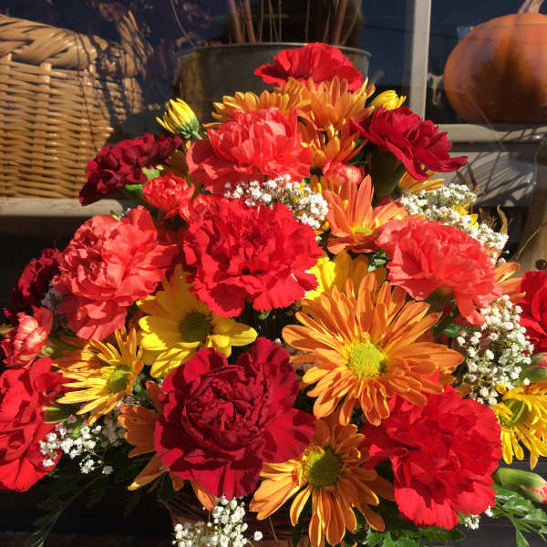 Basket arrangement of red, orange, and yellow flowers