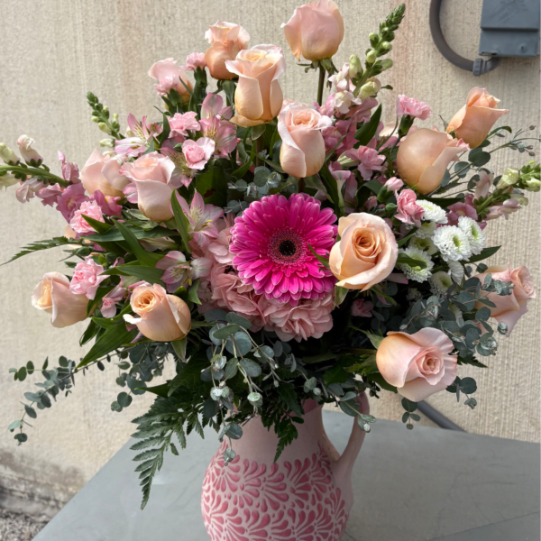 Pink and peach flower arrangement in a patterned vase