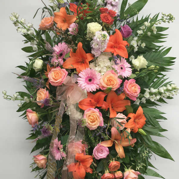 Large standing spray of orange lilies, pink roses, and gerbera daisies