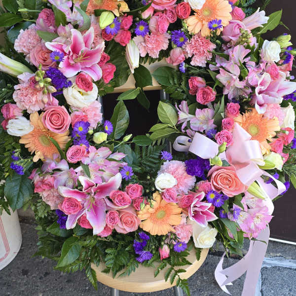 Heart-shaped floral wreath with pink and peach blooms and purple accents
