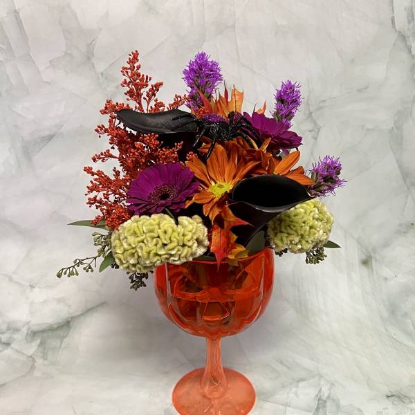Halloween bouquet in an orange goblet vase with black spider and orange flowers