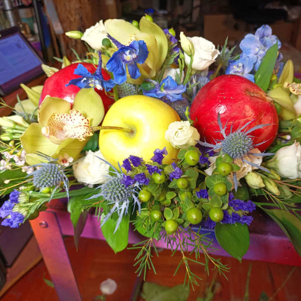 Mixed floral arrangement with apples and blue flowers