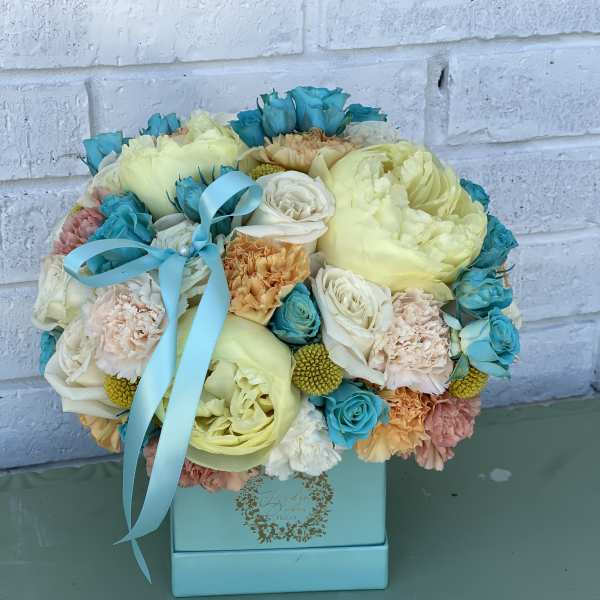 Bouquet of pastel flowers in a blue box with a ribbon
