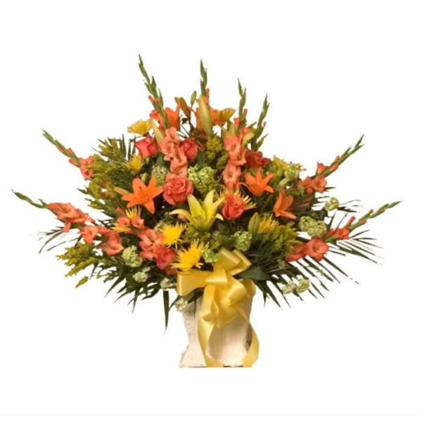 Orange and yellow mixed flower arrangement in a vase with a gold ribbon