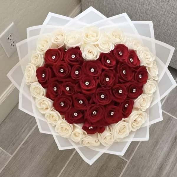 Heart-shaped bouquet of red and white roses with clear gem centers