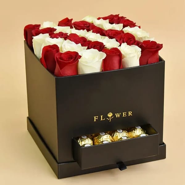 Red and white roses in a black gift box with chocolates in a drawer