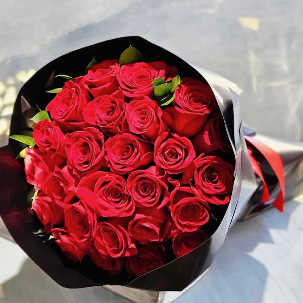 Bouquet of red roses wrapped in black and white paper
