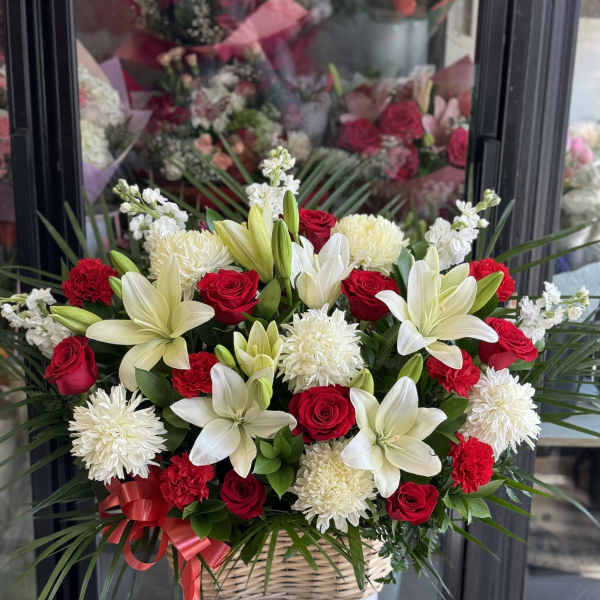 Basket arrangement of red roses, white lilies, and white chrysanthemums