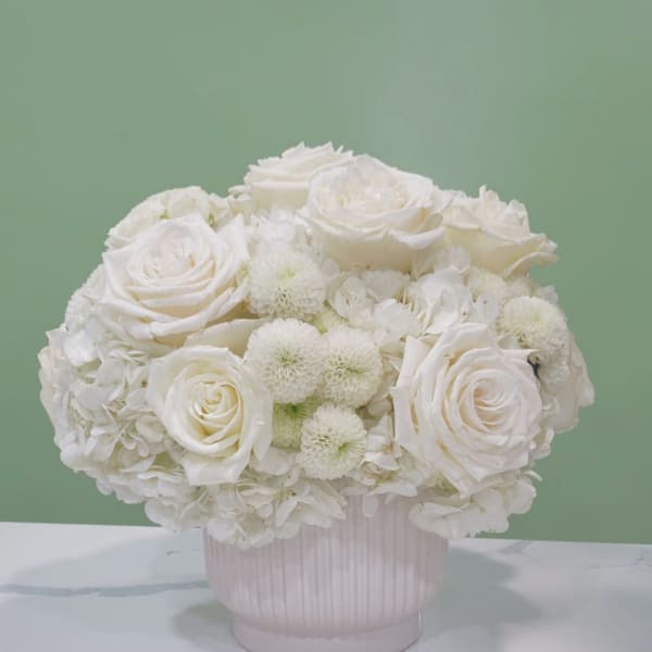 White rose and hydrangea arrangement in a ribbed vase