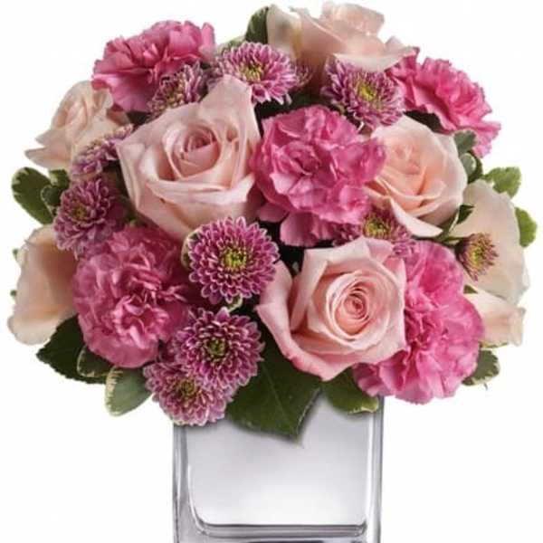Pink roses and carnations in a clear glass vase