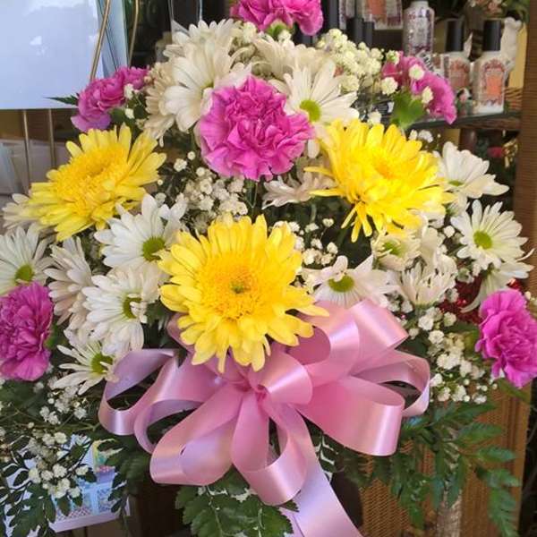 Bouquet of yellow and white daisies with pink carnations in a white vase