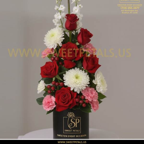 Tall red rose arrangement with white and pink flowers in a black box