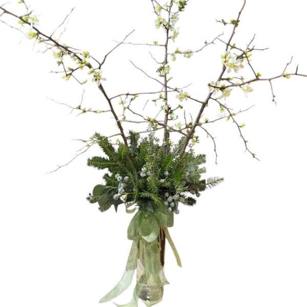 Tall branch arrangement with white blossoms in a glass vase