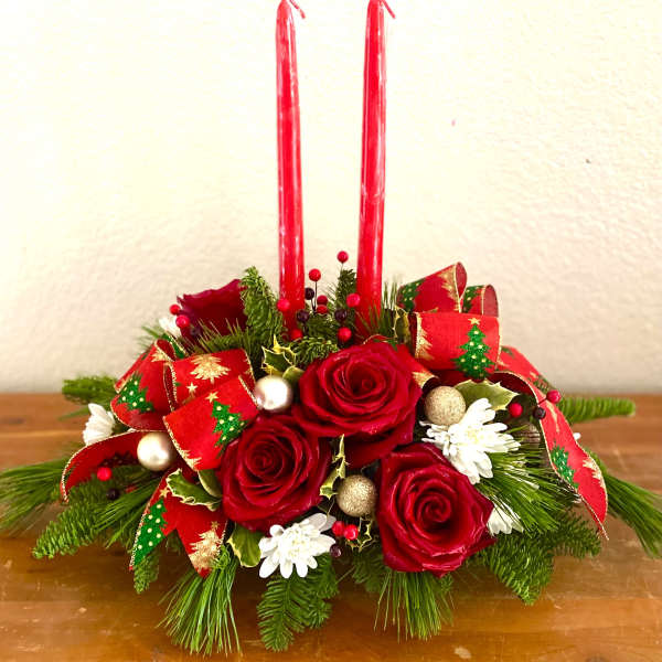 Red rose centerpiece with candles and holiday ribbon