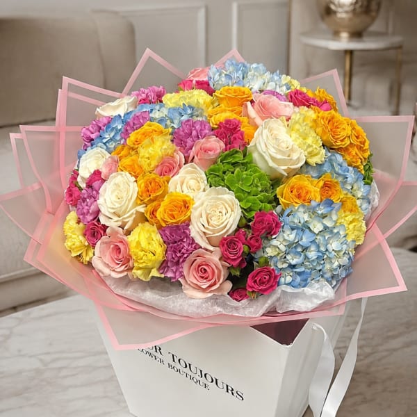 Large bouquet of multicolored roses and hydrangeas in a white gift box