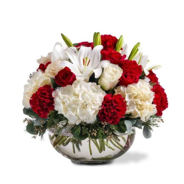 Red and white floral arrangement in a glass bowl vase