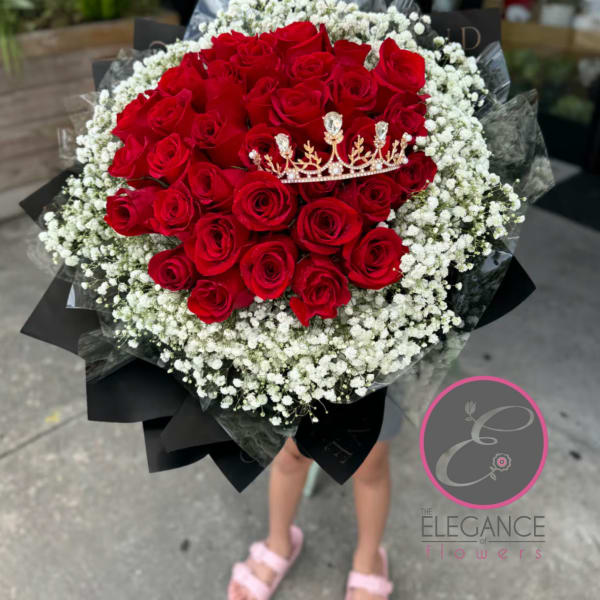 Bouquet of red roses with white baby's breath and a small crown topper