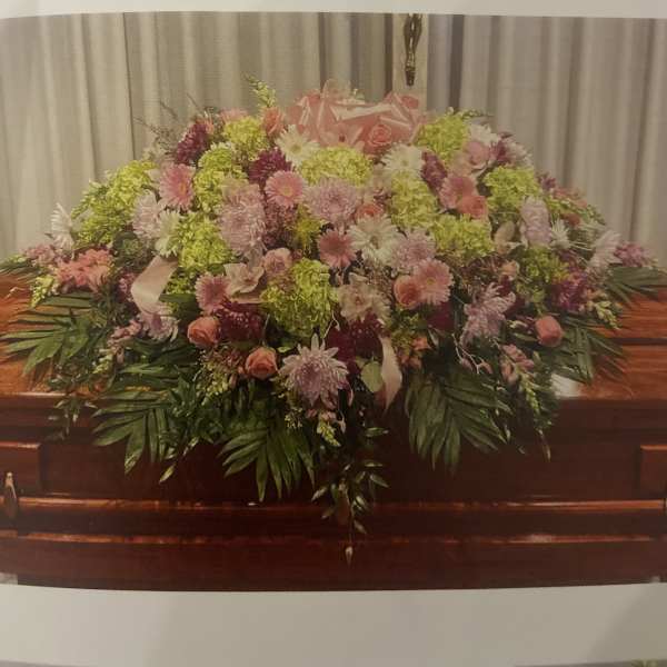 Large pink and green floral casket spray with mixed blooms