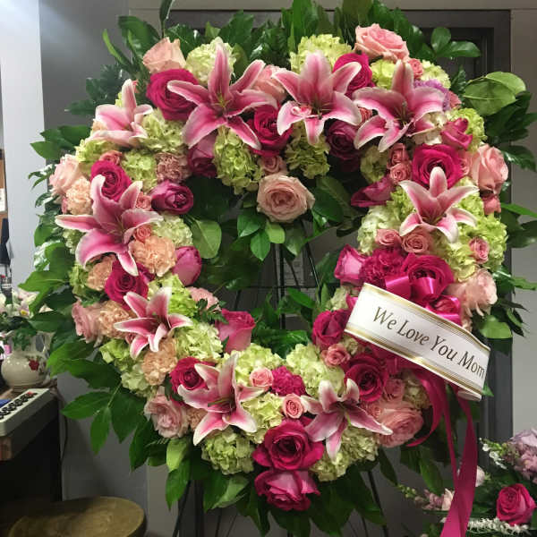Heart-shaped floral wreath with pink lilies, roses, and hydrangeas
