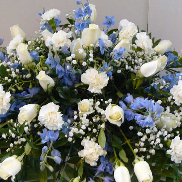 Large white and blue floral arrangement with roses and carnations
