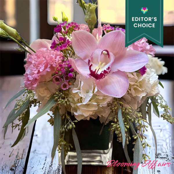 Pink orchid and hydrangea arrangement in a vase