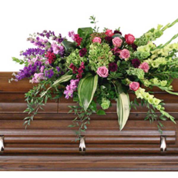 Casket spray with pink roses and purple flowers