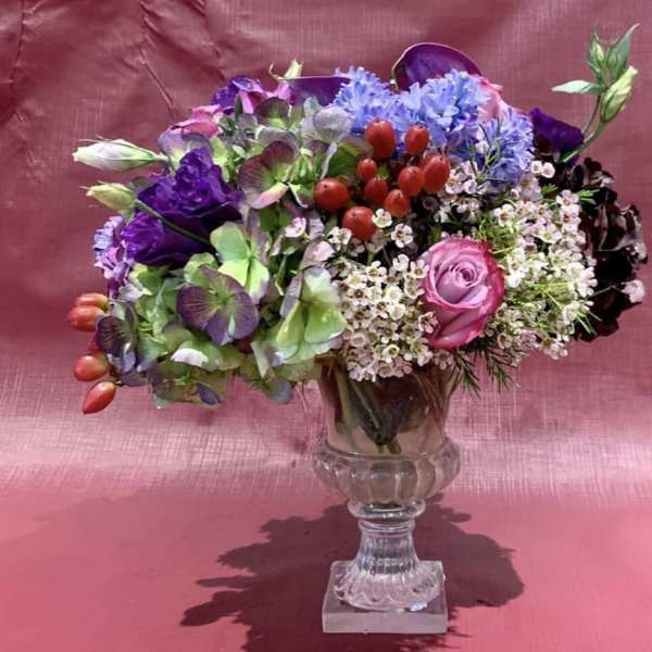 Mixed bouquet in a clear glass vase with purple, pink, and white flowers