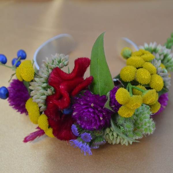 Colorful floral wrist corsage with yellow, purple, red, and blue blooms
