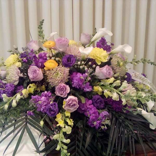 Large floral arrangement with purple, pink, yellow, and white blooms