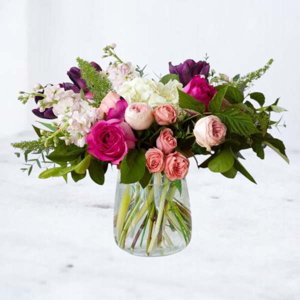 Mixed pink and white flowers in a clear glass vase