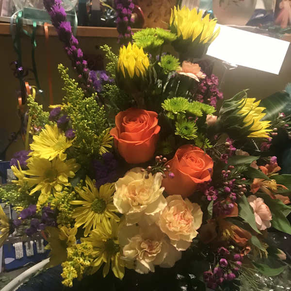 Colorful bouquet with orange roses, yellow daisies, and purple spikes