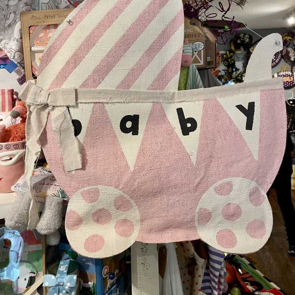 Pink fabric baby carriage wall hanging with polka dots and bunting