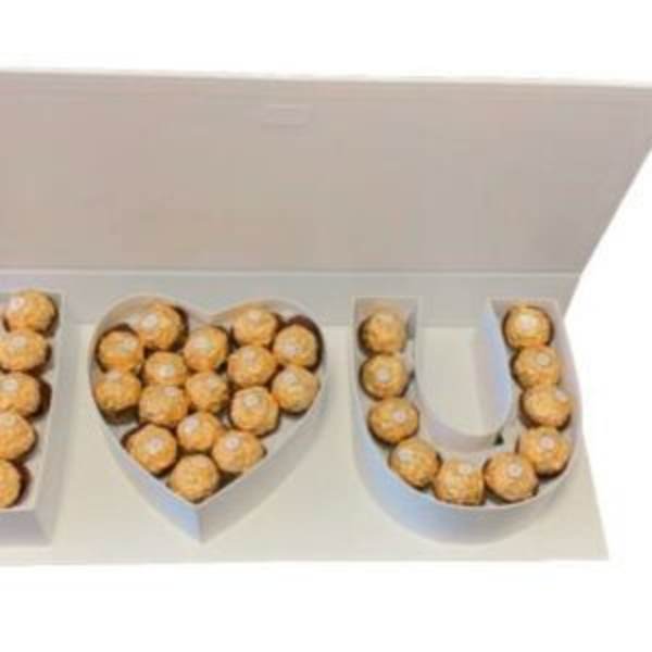 Heart and letter-shaped boxes filled with gold-wrapped chocolates