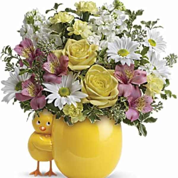 Yellow and white flower arrangement in a yellow chick vase