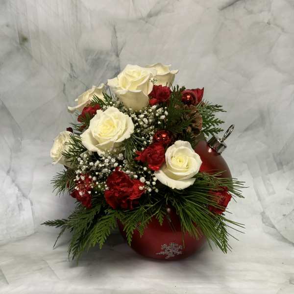 White roses and red carnations arranged in a red ornament-shaped vase