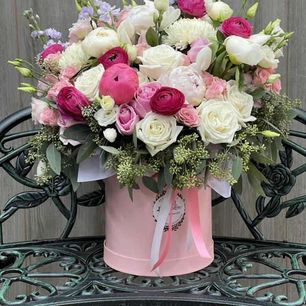 Pink and white mixed flower arrangement in a round pink box