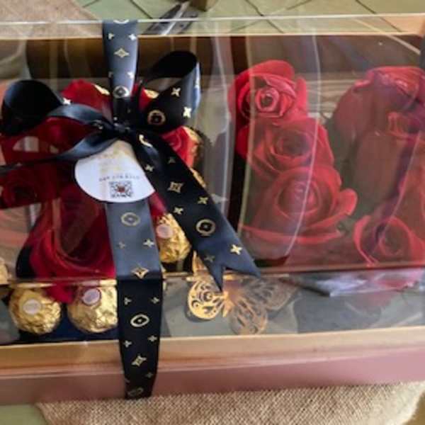 Boxed arrangement of red roses with gold Ferrero Rocher chocolates and a ribbon