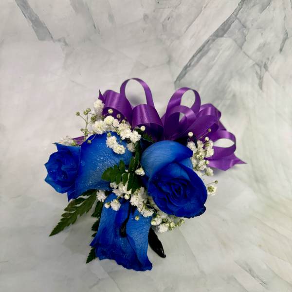 Blue roses with white baby's breath and a purple ribbon