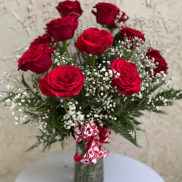 Bouquet of red roses with baby's breath in a glass vase