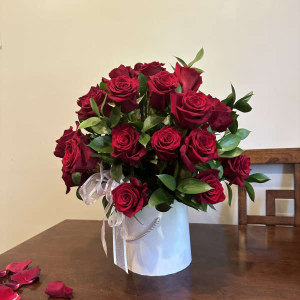Bouquet of red roses in a white hatbox with a ribbon