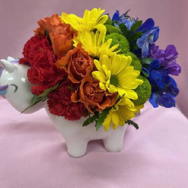 Rainbow flower arrangement in a unicorn-shaped ceramic container