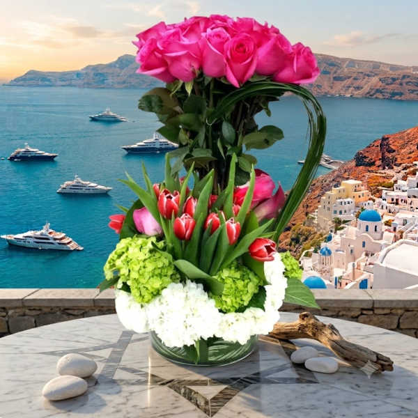 Tall bouquet of pink roses and red tulips in a glass vase