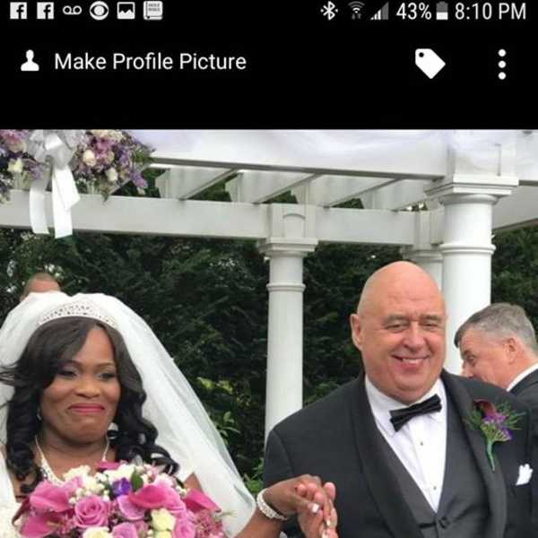Bride holding a pink and white bouquet beside a groom in a tuxedo