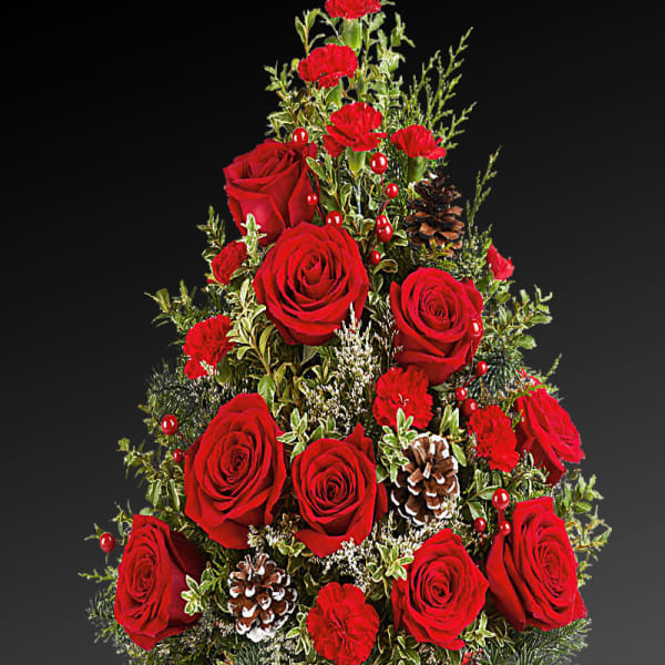 Red roses and carnations arranged in a red bowl with pinecones