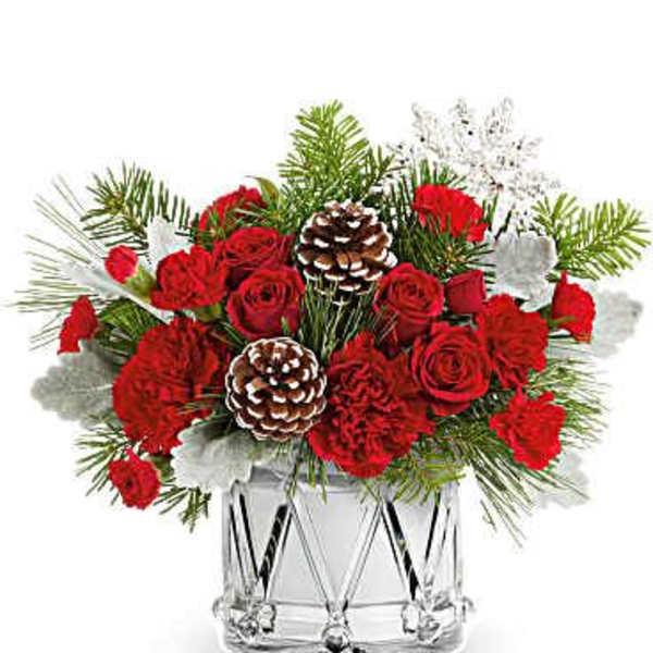 Red roses and carnations in a clear glass vase with pinecones