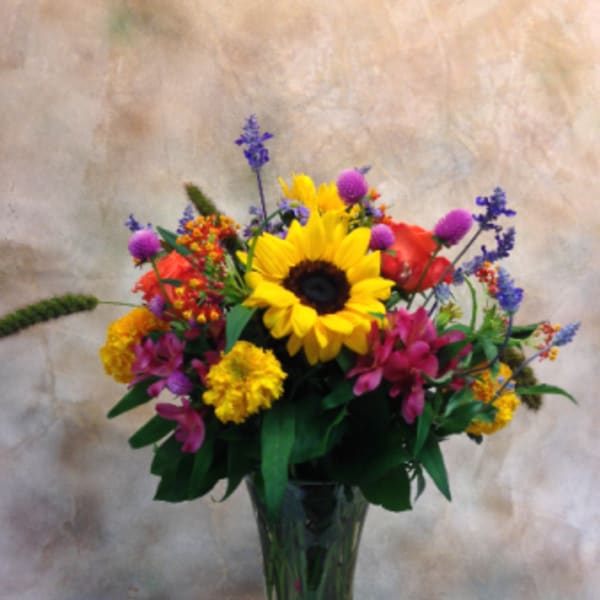 Mixed bouquet with a sunflower in a glass vase