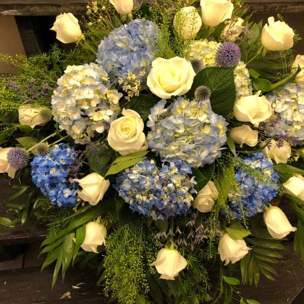 Blue hydrangeas and white roses arranged in a low bouquet